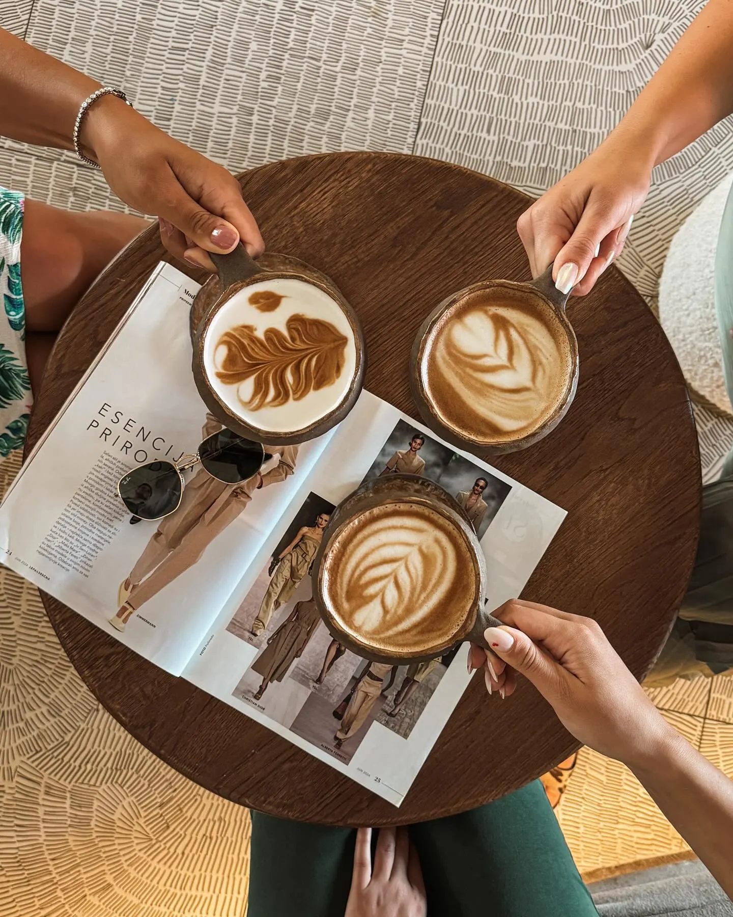Three friends enjoying coffee with different latte art patterns - social café atmosphere